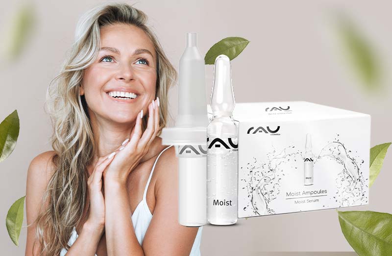 Lächelnde Frau mit gewellten Haaren neben AVU Moist Serum Ampullen und natürlichem Hintergrund aus Blättern.