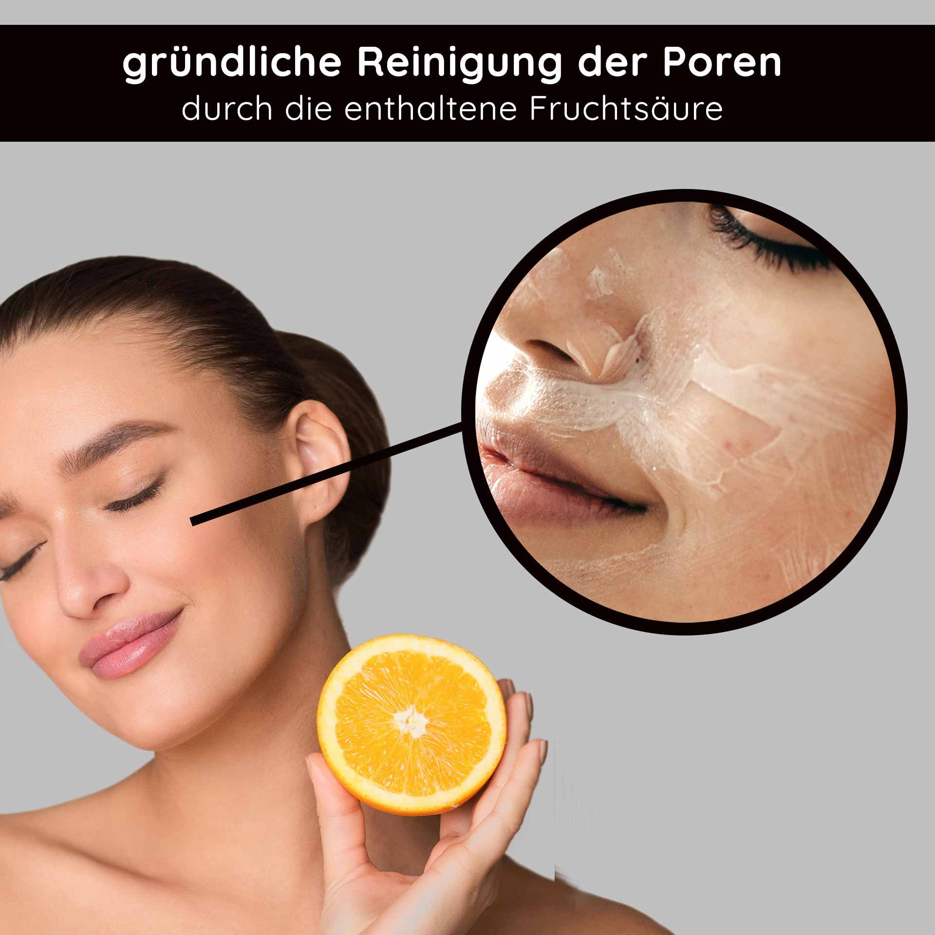 Woman with orange citrus fruit applying a facial cleanser with fruit acid, emphasizing thorough pore cleansing.