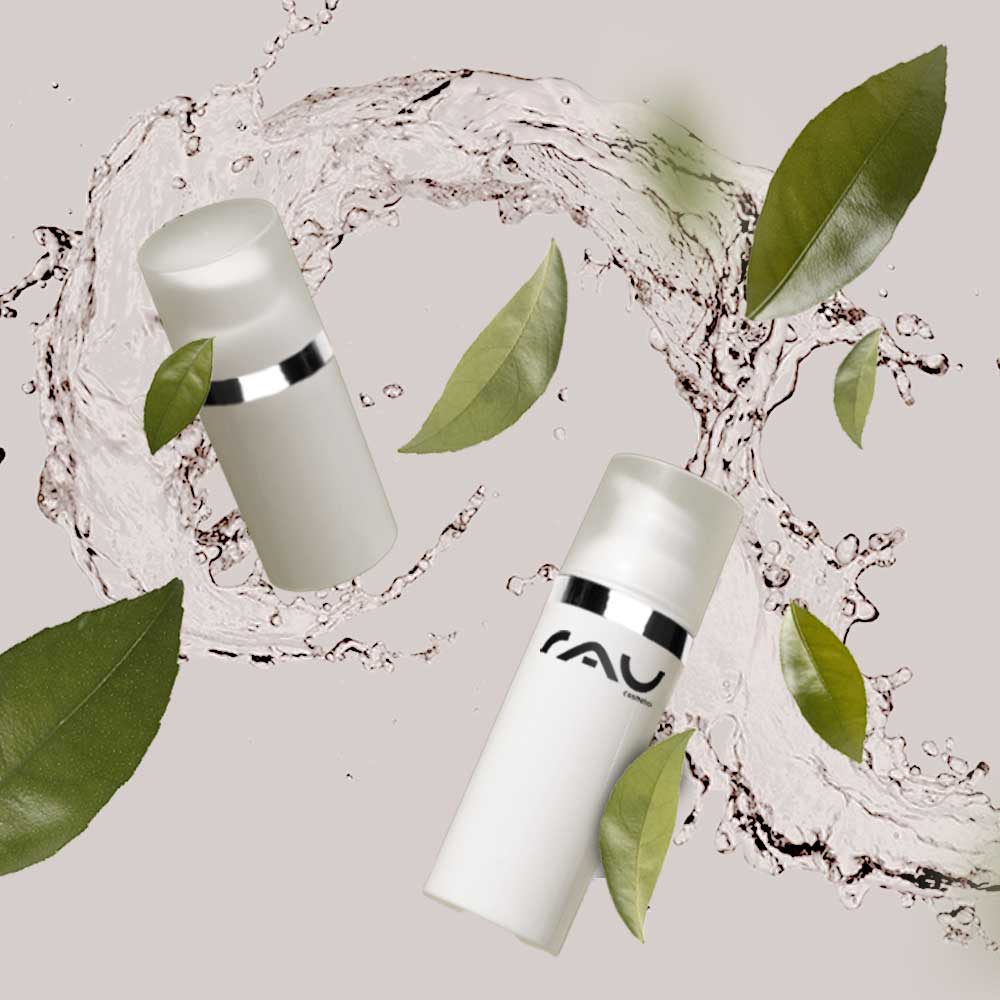 RAU_Cosmetics-wirkstoffkosmetik-gesichtspflege-hautpflege-onlineshop-kosmetik-kosmetikstudio-kabinenware-faire-preise Hautpflegeprodukte von RAU Cosmetics mit Wirkstoffen, umgeben von Wassertropfen und grünen Blättern, die Qualität und natürliche Elemente betonen.