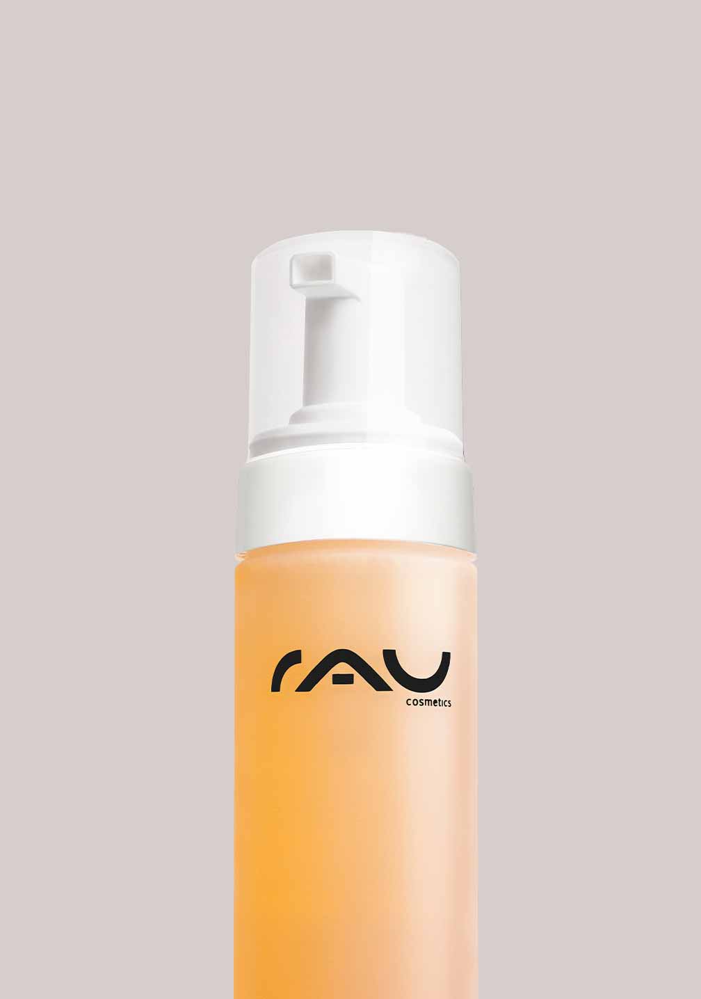 Reinigungsschaumflasche mit Pumpspender und RAU Cosmetics Logo auf beigem Hintergrund.