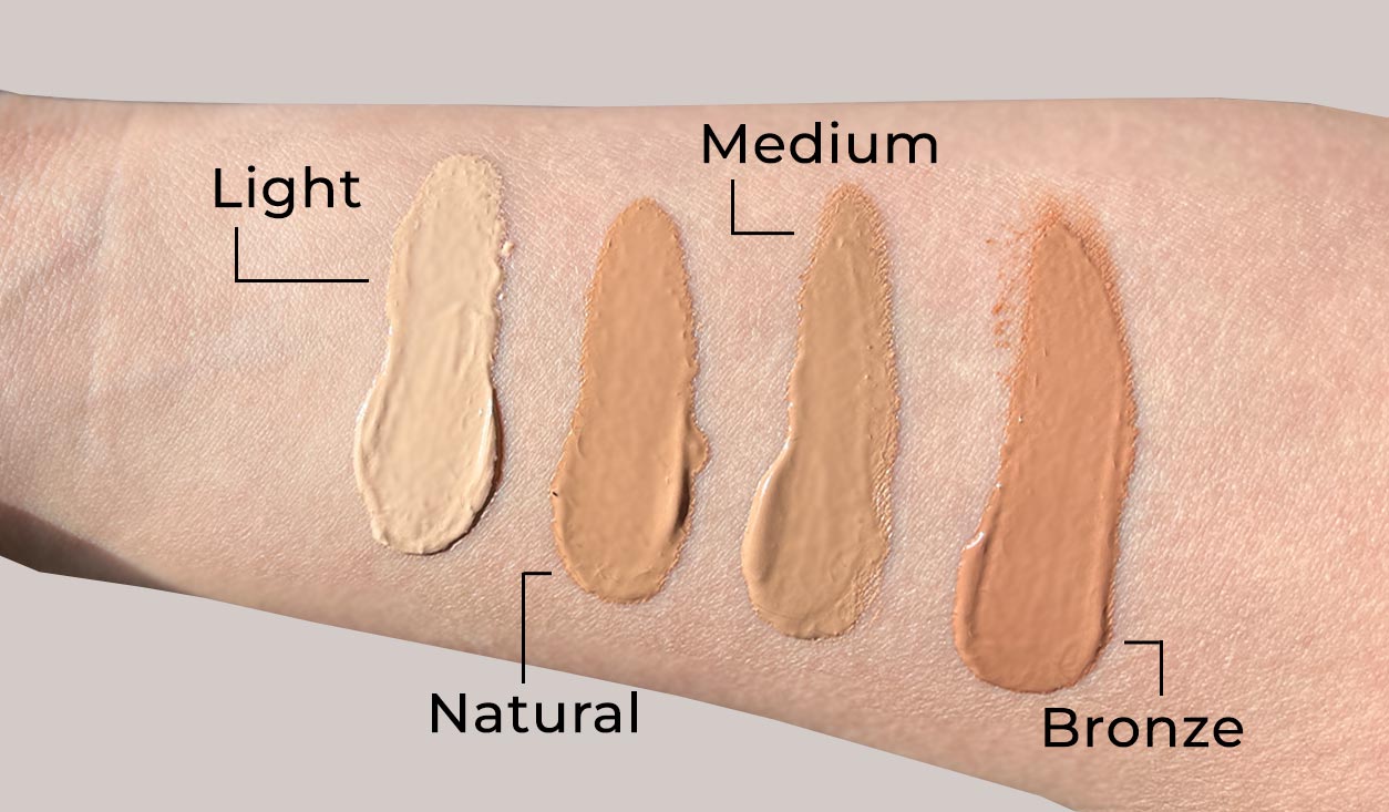 rau-cosmetics-bb-cream-getoente-tagescreme-gesichtspflege-hautpflege-foundation-makeup-pflegend-10 Farbmuster von vier BB-Creme-Farbtönen mit den Bezeichnungen Hell, Natürlich, Mittel und Bronze auf einem Hautton, die Möglichkeiten zum Erreichen eines ebenmäßigen, strahlenden Teints zeigen.