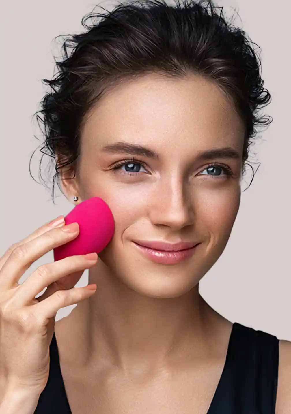 Frau mit Makeup-Schwamm, der einen natürlichen Look und die BB Cream Perfect Care Light von RAU Cosmetics anwendet.