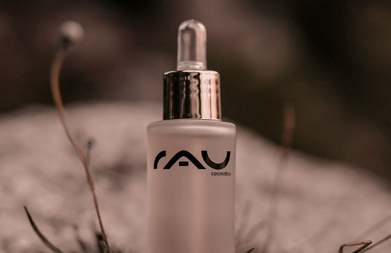 daily-face-oilzGqOykrOZebG-02 Flasche mit Gesichtsöl von RAU Cosmetics, transparentes Design, Pipette, im natürlichen Umfeld, passend zu entspannender Hautpflege-Routine.